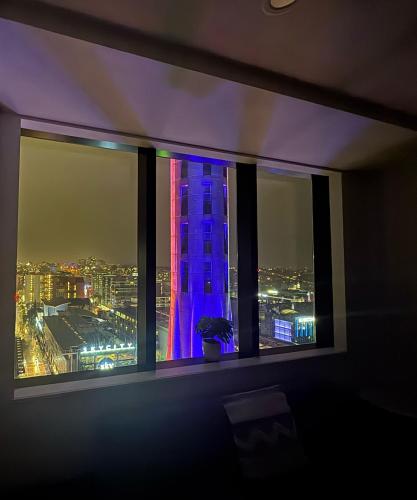 a window with a view of a city at night at Spacious Skytower view and Seaview 2 BDR 2 BTH Apartment in Auckland