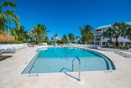 a swimming pool at a resort with palm trees at Sea Glass Cove by SoFLA Vacations in Marathon