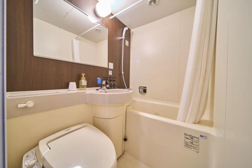 a small bathroom with a toilet and a sink at Via Inn Shin Osaka in Osaka