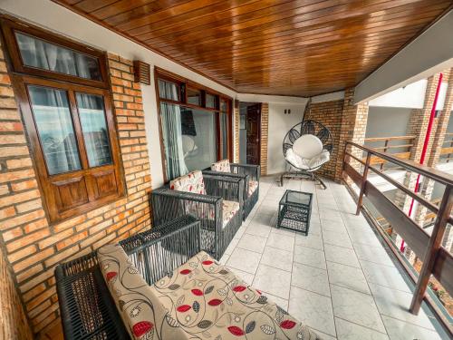 a balcony of a house with a couch and a chair at Falésia Praia Hotel in Canoa Quebrada