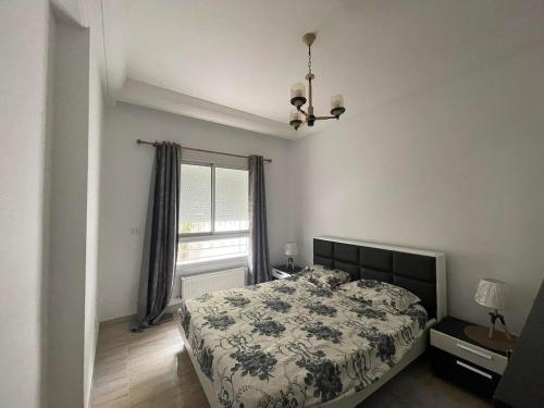 a bedroom with a bed and a window at Appartement avec une chambre et jardin in Bin Rhilouf