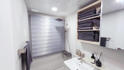een badkamer met een douche, wastafel en toilet bij Urban Retreat 3-Min Walk from Achasan Station, 15-Min to Seongsu, Tranquil Space for Relaxation in Seoul