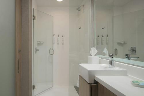 a white bathroom with a shower and a sink at SpringHill Suites by Marriott Lexington Frankfort in Frankfort