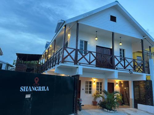 a white house with a fence in front of it at Casa De Shangrila in Belize City