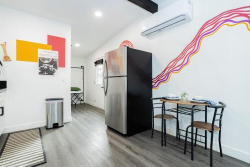 a kitchen with a refrigerator and a table at St Louis Premier Modern Vegas Escape Arts District & Patio in Las Vegas