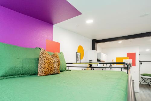 a bedroom with a green bed and colorful walls at St Louis Premier Modern Vegas Escape Arts District & Patio in Las Vegas