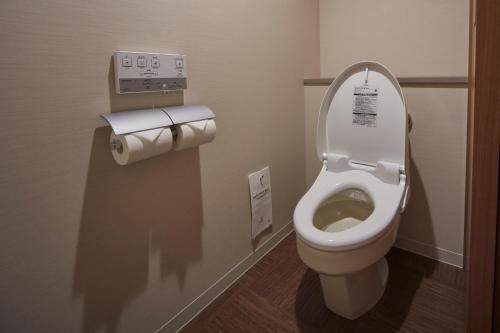 a bathroom with a toilet with a toilet paper dispenser at Sunshine City Prince Hotel Ikebukuro Tokyo in Tokyo