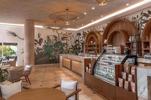 a restaurant with a mural of plants on the wall at Almare, a Luxury Collection Resort, Isla Mujeres, Adult All-Inclusive in Isla Mujeres
