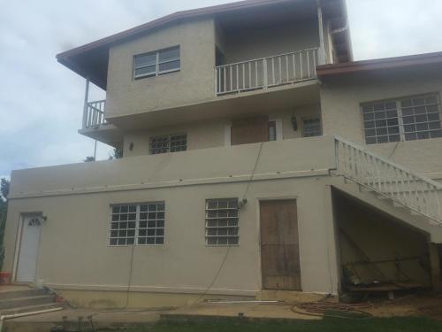 a large white building with a garage and a balcony at Tropical Westend Oasis in West End