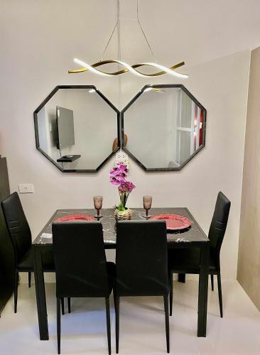a dining room with a black table and a mirror at Near Airport CASA ISABEL in Mactan Island