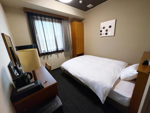 a hotel room with a bed and a window at Hotel Route-Inn Kani in Kani