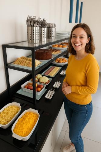 une femme debout devant un buffet de nourriture dans l'établissement Hotel Suntuoso, à Brasilia