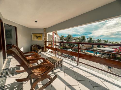 a balcony with chairs and a view of the ocean at Falésia Praia Hotel in Canoa Quebrada