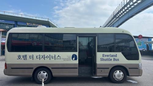 a white bus parked in front of a bridge at Hotel The Designers Incheon in Incheon