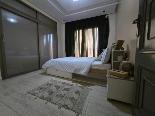 ein Schlafzimmer mit einem Bett und einem Fenster in der Unterkunft Appartement Moderne Gueliz in Marrakesch