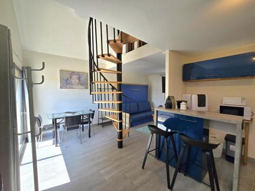 - une cuisine et une salle à manger avec un escalier en colimaçon dans un appartement dans l'établissement Charmant studio avec jardin privatif au cœur de la Dordogne - FR-1-616-329, à Coly