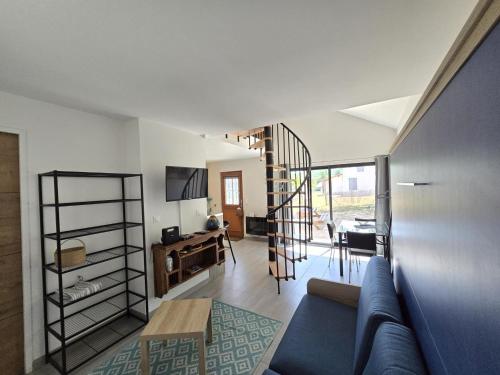- un salon avec un canapé bleu et un escalier dans l'établissement Charmant studio avec jardin privatif au cœur de la Dordogne - FR-1-616-329, à Coly