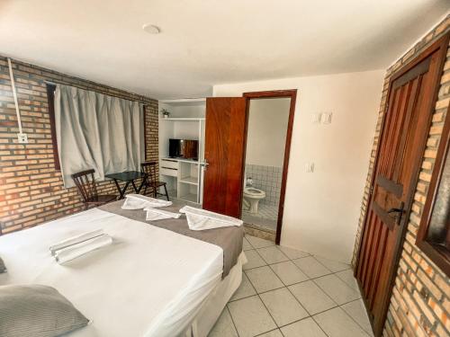 a bedroom with two beds and a bathroom with a tub at Falésia Praia Hotel in Canoa Quebrada