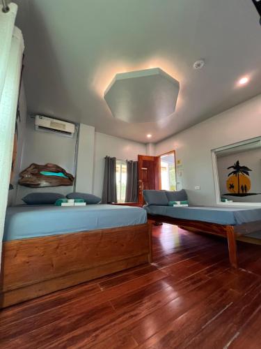 a bedroom with a large bed and a ceiling at L Cafe Restobar & Lyn's Guest House in San Juan