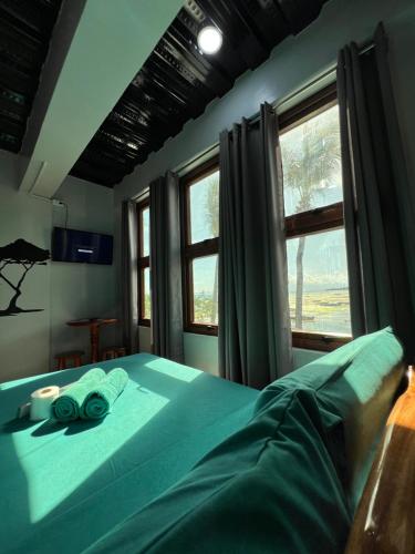 a bedroom with a bed with blue sheets and a window at L Cafe Restobar & Lyn's Guest House in San Juan
