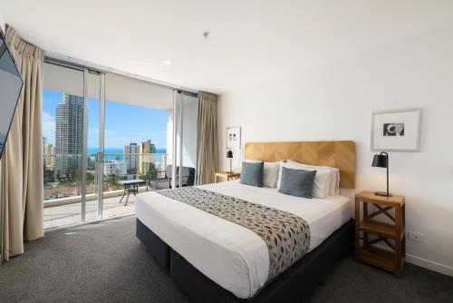 a hotel room with a bed and a large window at Artique Surfers Paradise - Official in Gold Coast