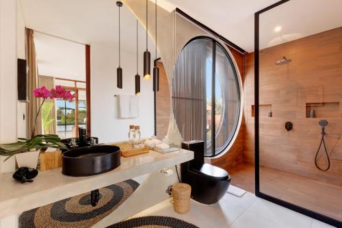 a bathroom with a sink and a shower at Baliwood Residence Villas by BREIG in Munggu