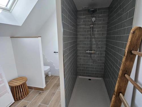 bagno con doccia e piastrelle grigie di Charmant Gîte 6 Pers avec Piscine Privée et Jardin, Avon-les-Roches - FR-1-381-629 a Avon-les-Roches