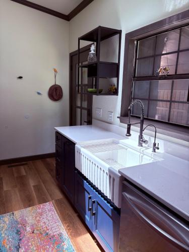 a kitchen with a sink and blue cabinets at Modern Mountainside Cabin in Bella Vista