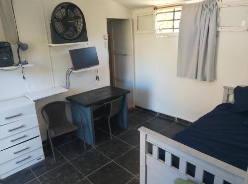 - une chambre avec un bureau, un lit et un bureau avec un ordinateur dans l'établissement Finca de montaña agua Gracian, à Pomancillo