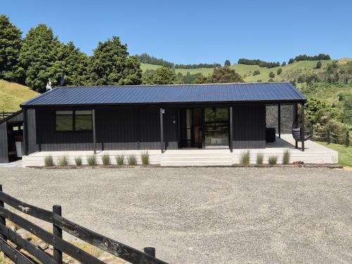 a black house with a fence in front of it at Te Tirohanga (The View) in Taumarunui