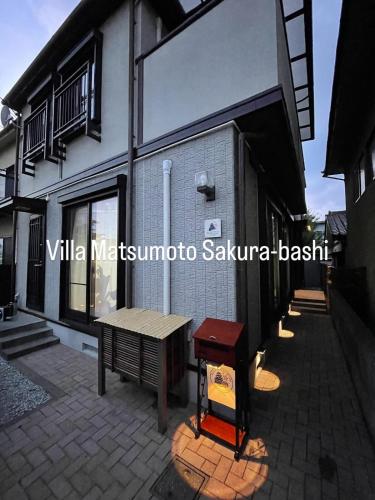 a building with a bench and a table on a patio at Villa松本桜橋 in Matsumoto
