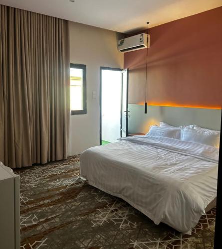 a bedroom with a large bed and a large window at شقق دخول ذاتي in Taif