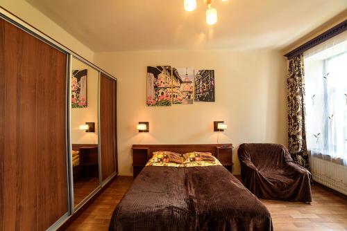 um quarto com uma cama e uma cadeira em Apartments Nekrasova-Rufa 23 em Lviv