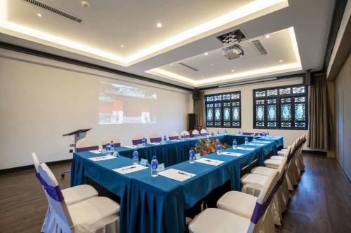 a meeting room with a long table with blue tables and chairs at No.3 Garden Hotel in Pi-chi Kuan