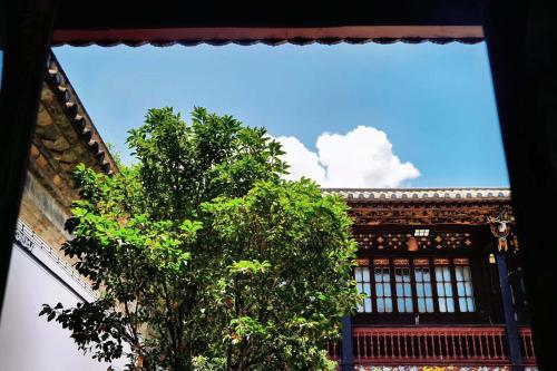 a tree in front of a building with a blue sky at No.3 Garden Hotel in Pi-chi Kuan