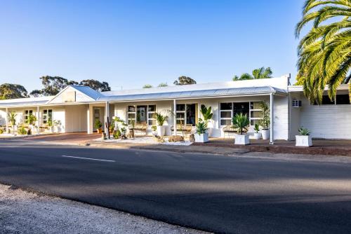 努里乌特帕Barossa Palms Motel的路边棕榈树的房子