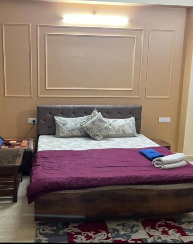 a bedroom with a large bed with purple sheets and pillows at Elite Heaven Retreat 1 BHK Budget Home Stay Tapovan in Tapovan