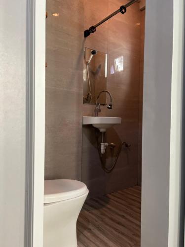 a bathroom with a toilet and a sink at L Cafe Restobar & Lyn's Guest House in San Juan