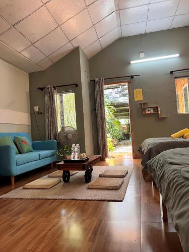 a living room with two beds and a couch and a table at Trại Hoa Vàng Homestay at Phú Yên in Ðông Tác (1)