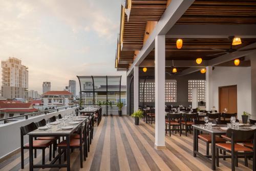 a restaurant with tables and chairs on a balcony at Queen Mansion in Phnom Penh
