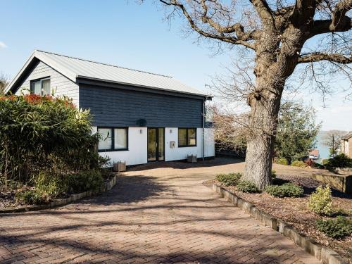 a white house with a tree and a driveway at Solent Lawns in Gurnard