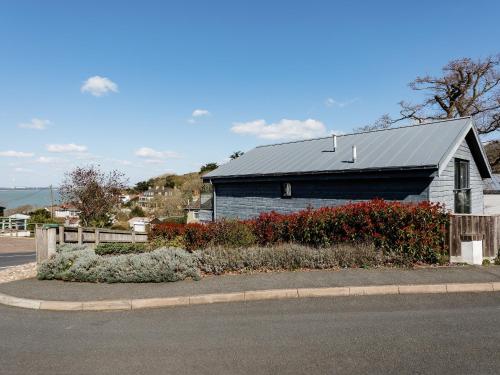 a blue building with a gray roof next to a street at Solent Lawns in Gurnard