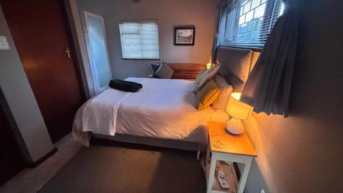 a small bedroom with a bed and a window at Eike Cottage in George
