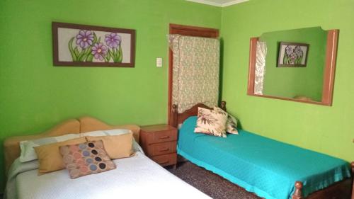 two beds in a room with green walls at Donarmando in Tandil
