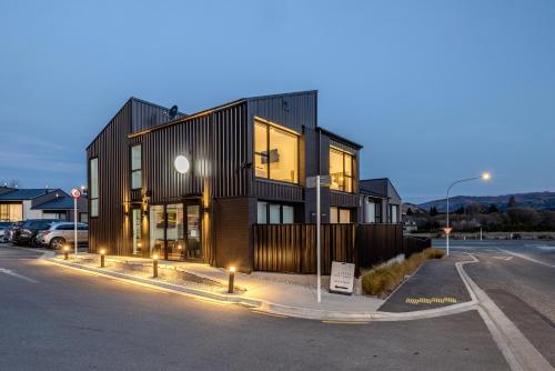 a building with lights on the side of a street at Alpine Junction Townhouse Apartments, Lodge & Hotel in Wanaka