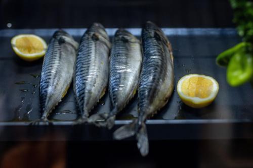 a group of fish on a grill with an orange slice at SOMA HOTEL Riverside in Phnom Penh