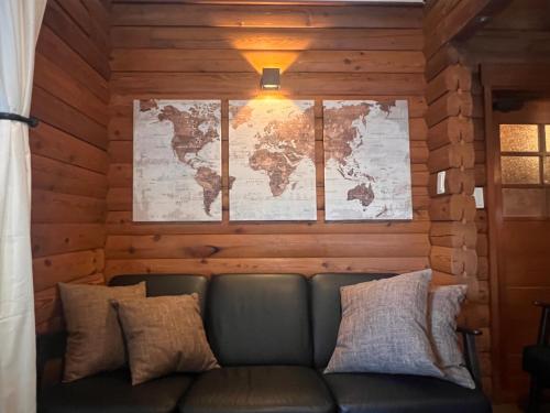 a couch in a room with a map on the wall at Villa Noël Kitakaruizawa Seiryu Sauna & Open Air Bath in Tsumagoi