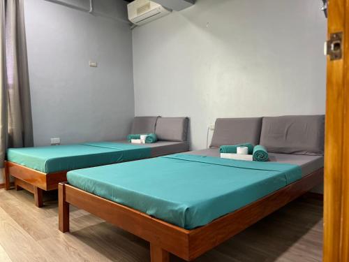a room with two beds and a couch at L Cafe Restobar & Lyn's Guest House in San Juan