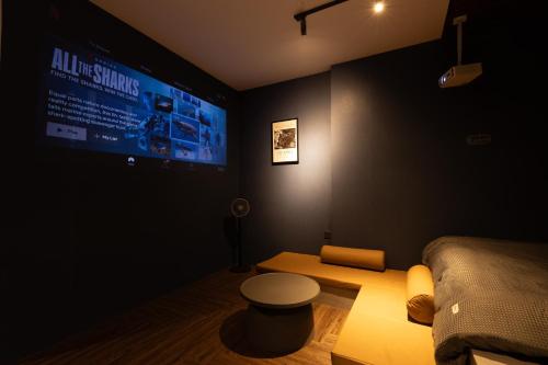 a dark room with a bed and a large screen at Midas Home in Da Lat