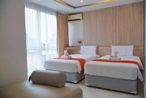 a hotel room with two beds with stuffed animals on them at D Eco Wellness Center in North Pattaya